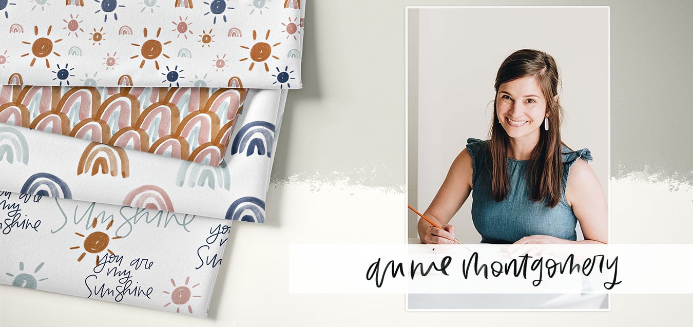 Folded fabrics with sun, rainbow, and "You are my sunshine" prints in rust, blush, navy; portrait of designer Annie Montgomery sketching.