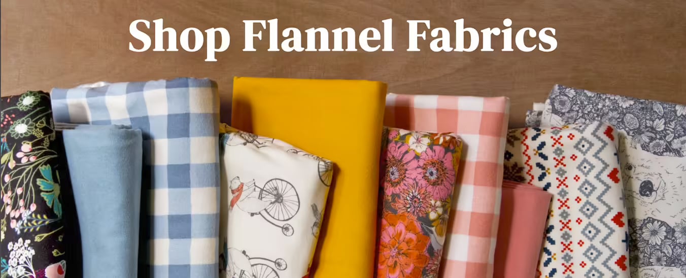 Rolled flannel fabrics in floral, gingham, bicycle print, and solid yellow, blue, pink, and gray patterns with 'Shop Flannel Fabrics' text