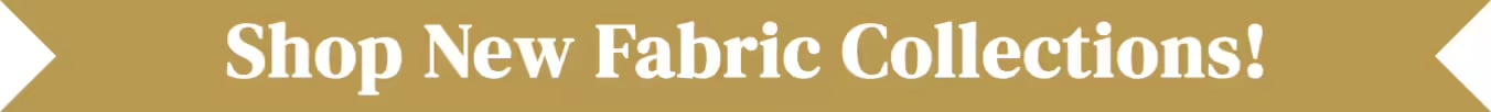 Gold banner with ribbon-style pointed ends reading "Shop New Fabric Collections!" in white text