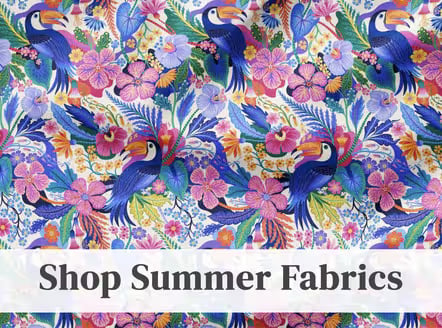 Colorful tropical fabric with toucans, palm leaves, and pink and purple flowers, banner reads Shop Summer Fabrics